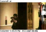 Surveilance camera photo of suspect Robert Hawkins aiming an AK-47 type rifle in the Westroads Von Maur store