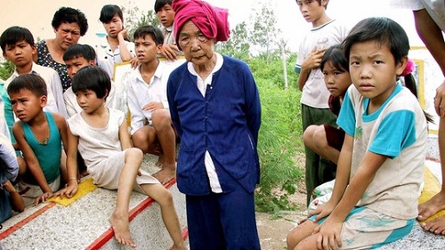Bà Bùi Thị Nhi, 73 tuổi (giữa) tại mộ của cha mẹ và 3 người cháu gái của bà đã thiệt mạng trong cuộc thảm sát ở Thạnh Phong, Bến Tre, năm 1969. Ảnh: Tư liệu